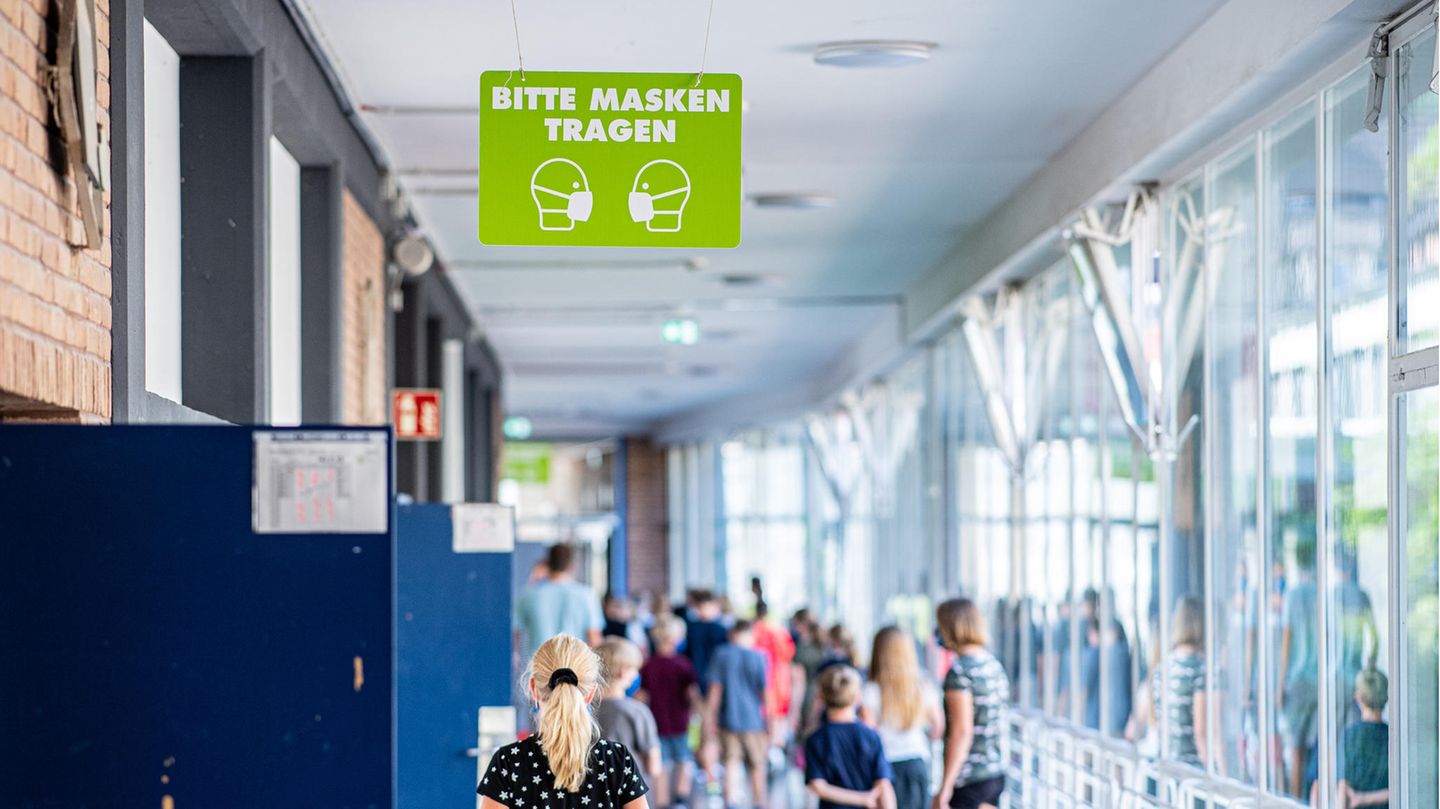 Auf dem Flur der Gesamtschule in Münster, hängt ein Schild mit der Aufschrift: "Bitte Masken tragen"