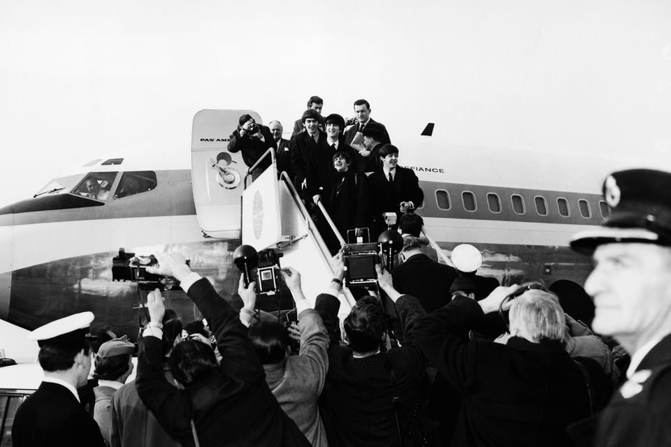 Als sie in London das Flugzeug bestiegen, waren sie nur eine sehr erfolgreiche britische Band. Doch als die Beatles am 7. Februar 1964 das Flugzeug verließen, wurden sie empfangen wie Weltstars: 5000 Fans und 200 Journalisten bereiteten den Beatles auf dem Rollfeld des New Yorker Flughafens einen überwältigenden Empfang. Wenige Wochen zuvor hatte ihre Single "I Want to Hold Your Hand" bereits in den USA die Chartspitze erobert. Ein erster Erfolg, doch erst mit ihrer Ankunft vor genau 50 Jahren wurden die Beatles auch jenseits des Kanals zur wohl größten Popband, die es je gegeben hat. Im April 1964 besetzten sie dort sogar die ersten fünf Plätze der Single-Charts. Auch das hat es davor und danach nicht mehr gegeben.