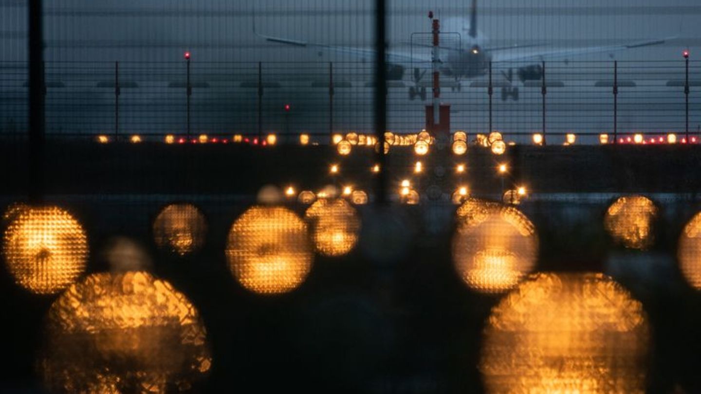 Ein Flugzeug landet hinter Signallichtern auf einem Flughafen. Foto: Sebastian Gollnow/dpa/Symbolbild