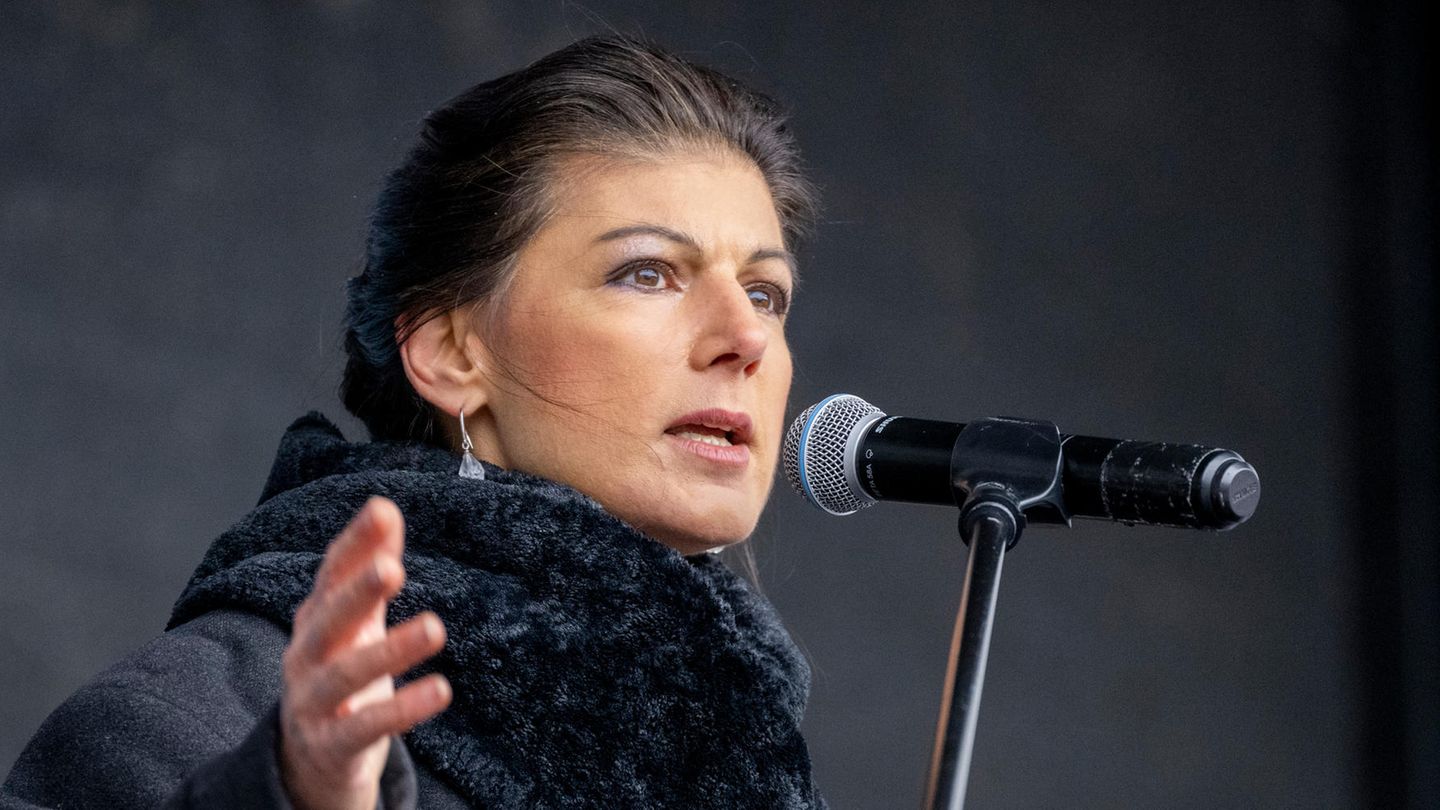 Sahra Wagenknecht steht schwarz gekleidet und gestikuliert, während sie in ein Mikro spricht