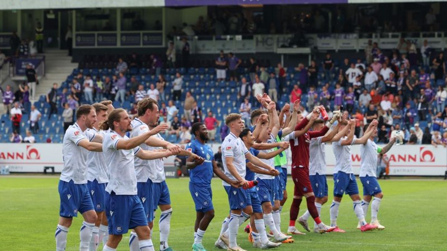 Karlsruhes Spieler feiern den Sieg bei Spielende. Foto: Friso Gentsch/dpa