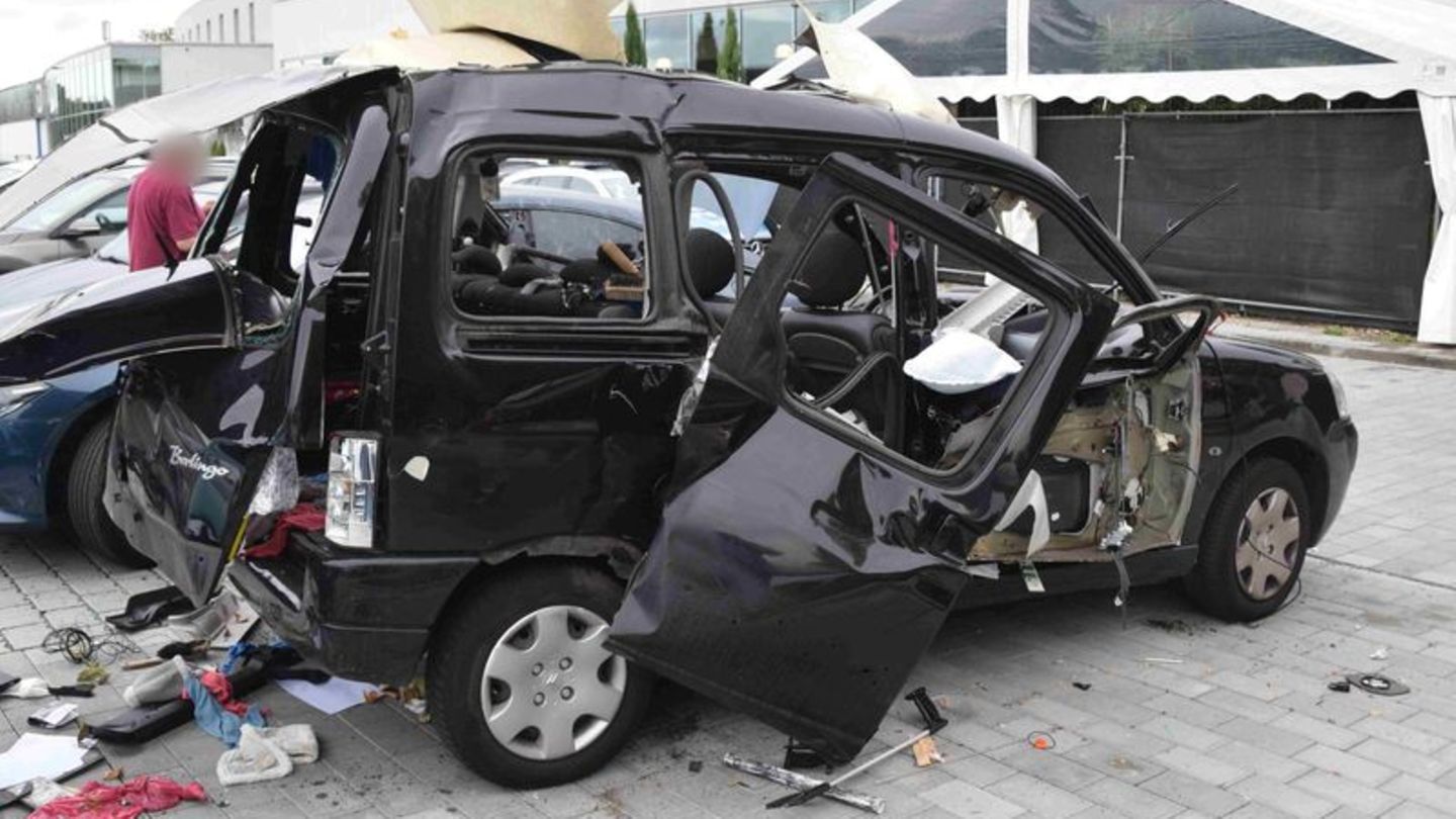 Ein Auto steht zerstört auf einem Parkplatz. Foto: Rene Priebe/dpa