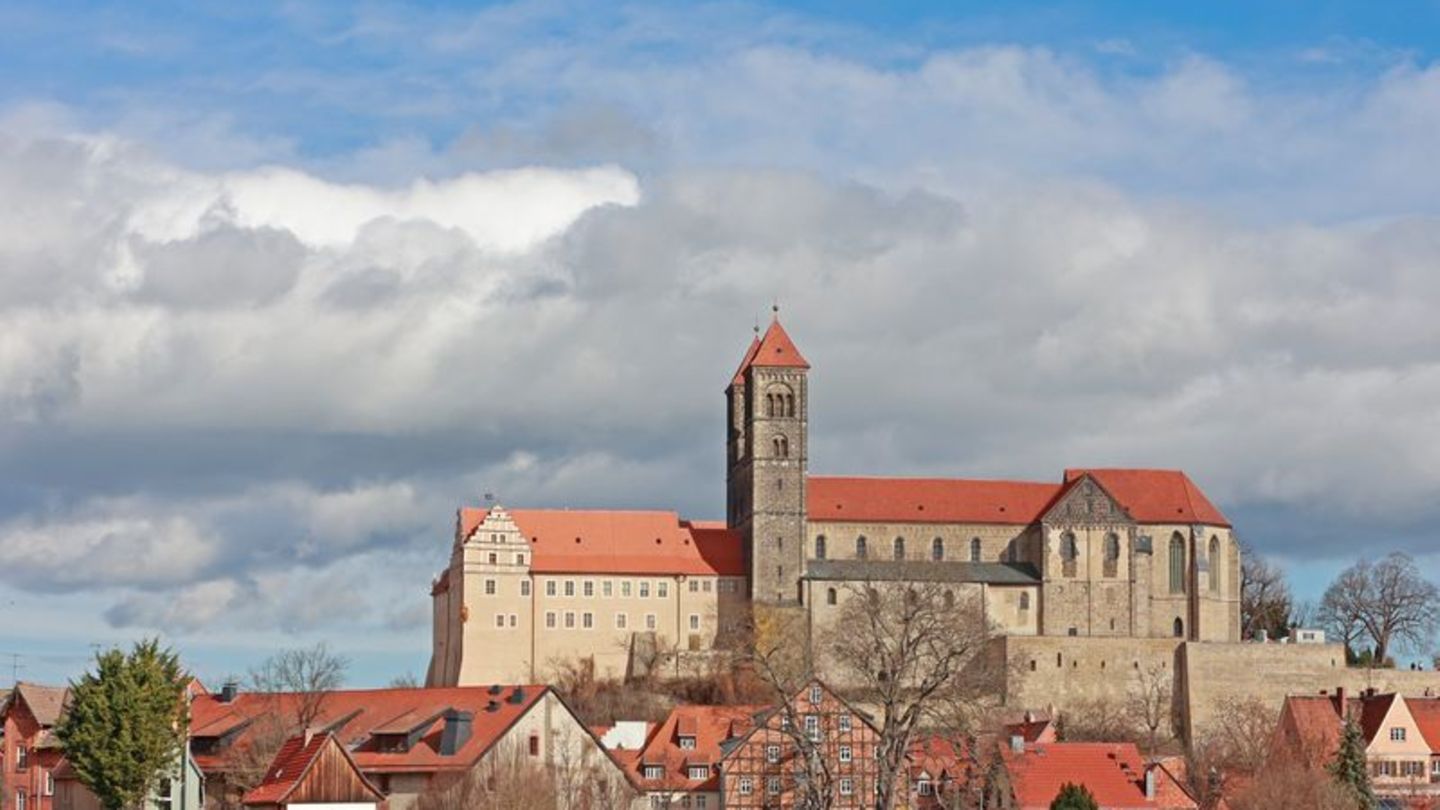 Dunkle Wolken stehen über der Stiftskirche in Quedlinburg. Foto: Matthias Bein/dpa